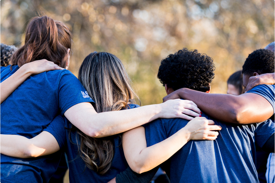 Group of volunteers facing away from the camera in a huddle